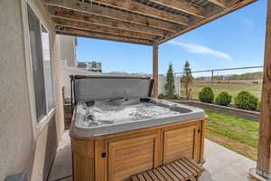 View of patio / terrace with fence and a hot tub