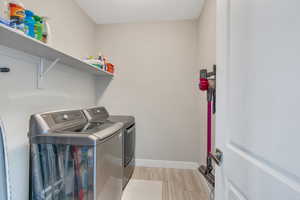Laundry room featuring baseboards, washer and clothes dryer, and laundry area
