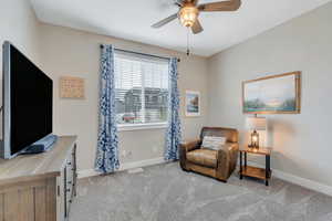 Living area featuring visible vents, a ceiling fan, baseboards, and carpet floors