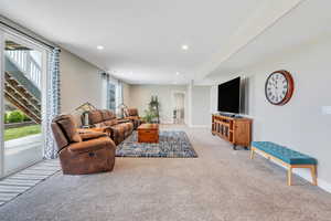 Living room with recessed lighting, baseboards, and light carpet