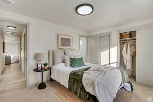 Bedroom with multiple closets and light colored carpet