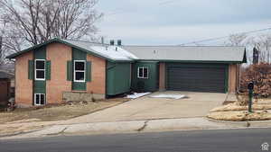 Ranch-style home featuring brick siding, an attached garage, driveway, and roof with shingles