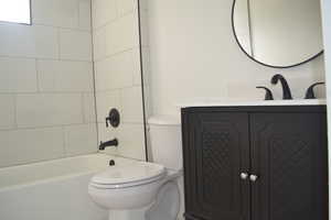 Full bath featuring toilet, vanity, and  shower combination