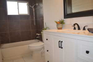Full bathroom with toilet, vanity, and shower / washtub combination