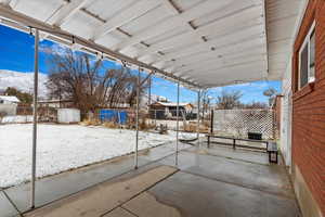 Snow covered patio featuring fence