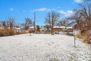 Yard layered in snow featuring fence