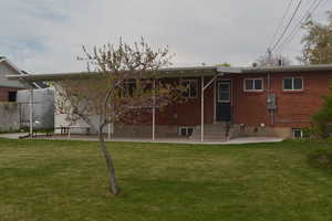Back of house with a lawn, entry steps, and a patio