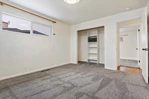 Unfurnished bedroom with visible vents, baseboards, carpet flooring, and a closet