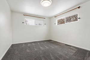 Carpeted spare room with baseboards and visible vents