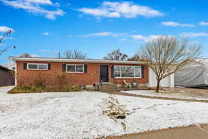 Single story home featuring brick siding and a garage
