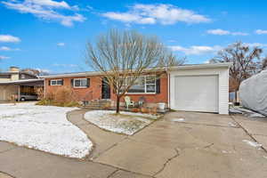 Ranch-style home with an attached garage, brick siding, and concrete driveway