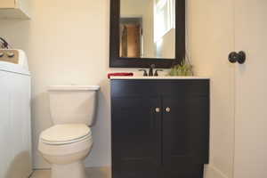 Bathroom with toilet, washer / clothes dryer, and vanity