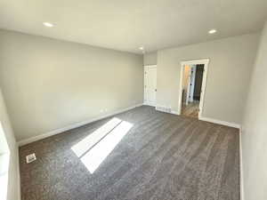 Unfurnished bedroom with recessed lighting, carpet floors, visible vents, and baseboards