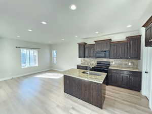 Kitchen featuring black appliances, tasteful backsplash, a sink, and recessed lighting
