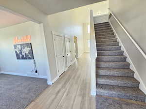 Staircase featuring visible vents, baseboards, and wood finished floors