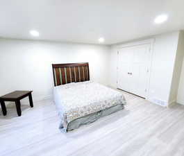 Bedroom featuring baseboards, wood finished floors, visible vents, and recessed lighting