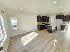 Kitchen featuring black appliances, backsplash, a sink, and visible vents