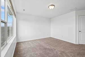 Carpeted spare room with baseboards and visible vents