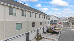 Exterior space with an attached garage, a mountain view, and a residential view