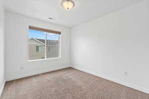 Empty room featuring baseboards, carpet flooring, and visible vents