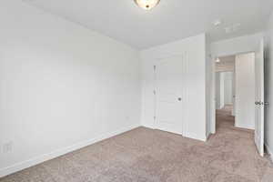 Unfurnished bedroom with baseboards and carpet