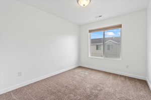 Carpeted empty room featuring baseboards and visible vents