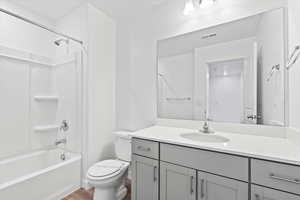 Full bathroom with  shower combination, toilet, visible vents, wood finished floors, and vanity