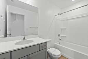 Full bath featuring wood finished floors, visible vents, shower / bath combination, toilet, and vanity