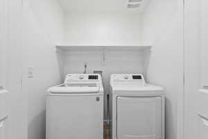 Washroom with washer and clothes dryer and laundry area