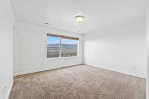 Unfurnished room with baseboards, visible vents, and carpet