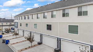 Exterior space with stucco siding, driveway, and a garage