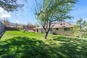 View of yard with a fenced backyard and central AC unit