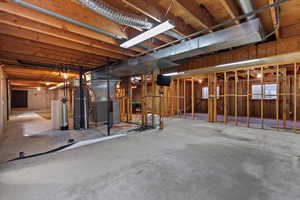 Unfinished below grade area with heating unit and gas water heater