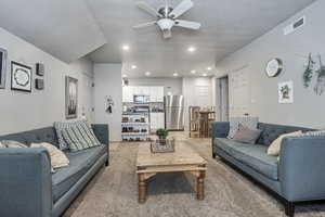 Living area with recessed lighting, a textured ceiling, and ceiling fan