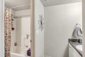 Full bath featuring tile floors, a textured ceiling, a vanity, a shower/bathtub combination, and a toilet