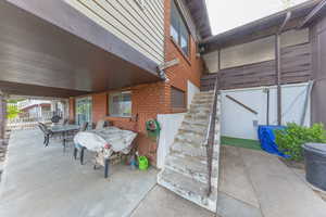 Covered back patio. Stairs lead up to rear entry of carport. Workshop is under the carport.