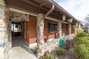 Covered front porch featuring stone columns. This home appraised at $530k on 4/15/25.