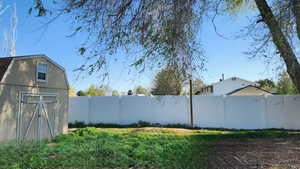 View of back yard with a fenced backyard, an outdoor structure, and a shed