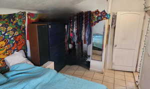 Bedroom with a textured ceiling and tile patterned floors