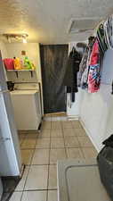 Laundry room featuring attic access, washer / dryer, a textured ceiling, and laundry area
