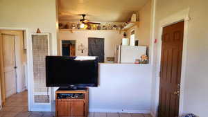 Interior space with baseboards, a ceiling fan, and tile patterned flooring