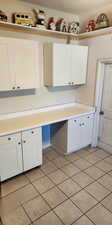 Kitchen featuring light countertops, light tile patterned flooring, and white cabinetry