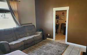 Living area featuring plenty of natural light, baseboards, and light tile patterned floors