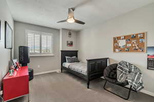 Carpeted bedroom featuring baseboards and a ceiling fan