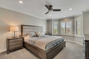 Master bedroom featuring light colored carpet, baseboards, crown molding, and recessed lighting