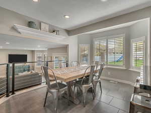 Dining area with bay window, tile flooring, baseboards, and recessed lighting