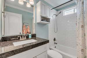 Bathroom featuring crown molding, granite counters, subway tile shower surround