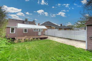 Rear view of property with fence, a lawn, and a patio area