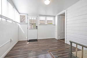 Entrance foyer with dark wood-type flooring and baseboards