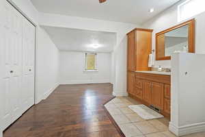 Bathroom featuring hardwood / wood-style floors, vanity, baseboards, and visible vents